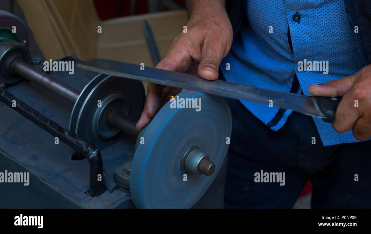 Man Schleifen auf abrasive schneiden und Messer - Schleifsteine Stockfoto