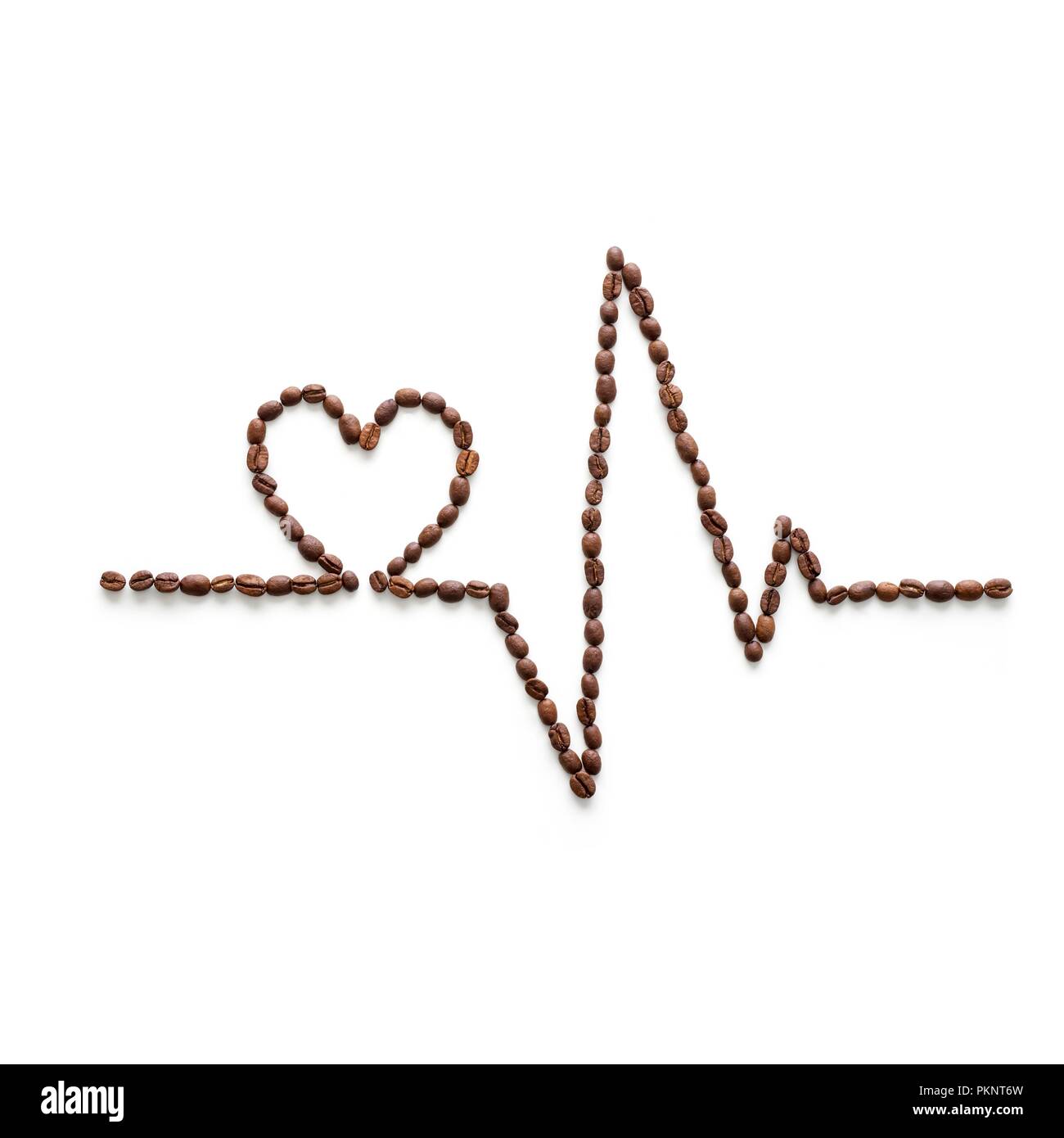 Kaffeebohnen, ein Elektrokardiogramm und Herz Form. Stockfoto