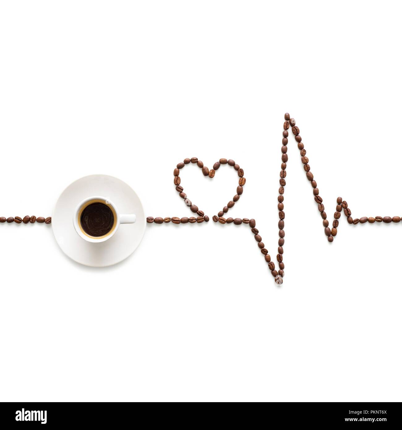 Kaffeebohnen, ein Elektrokardiogramm und Herzform, mit einer Tasse Kaffee. Stockfoto