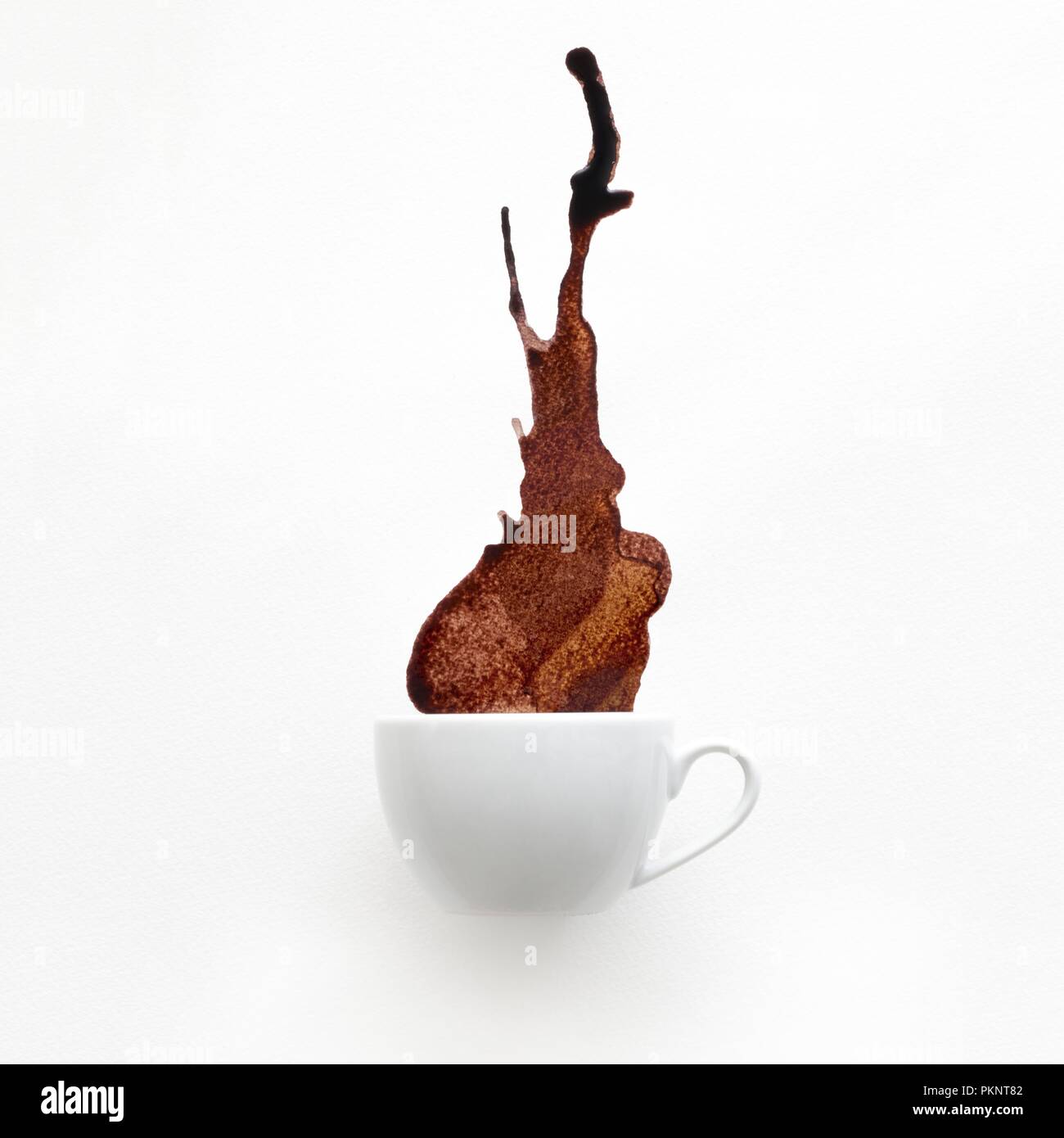Tasse Kaffee verschütten vor einem weißen Hintergrund. Stockfoto