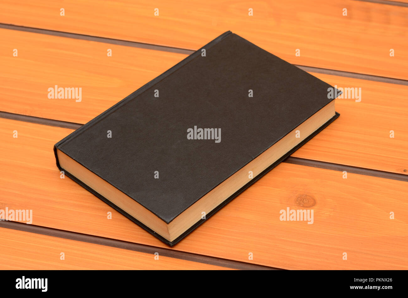 Schwarzes Buch mockup auf Holztisch, Studie Thema Stockfoto