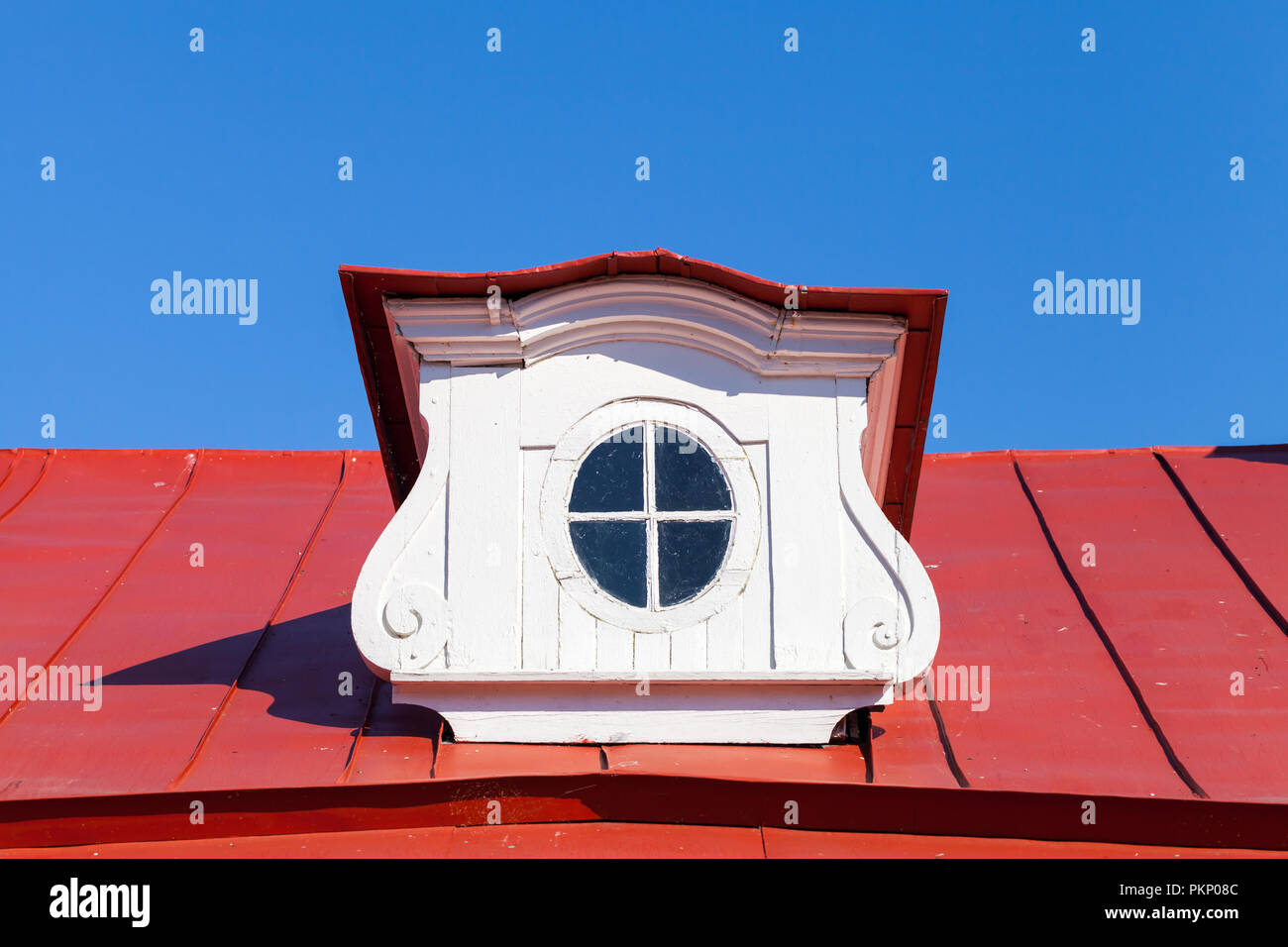 Vintage Dachfenster auf Red Roof slope in dekorativen weißen Holzrahmen Stockfoto