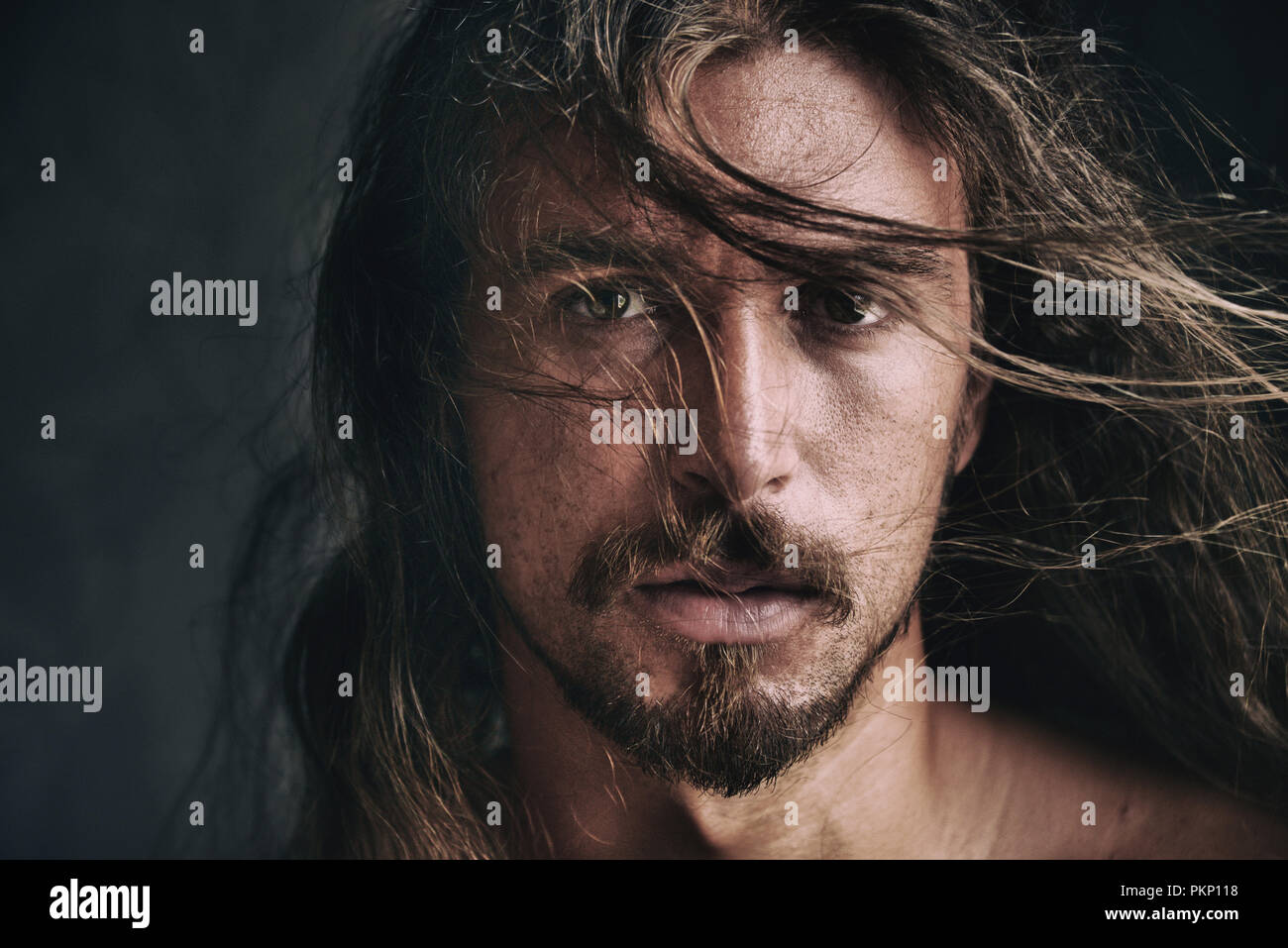 Emotionale Portrait von einem gutaussehenden jungen Mann mit Haaren über sein Gesicht Stockfoto