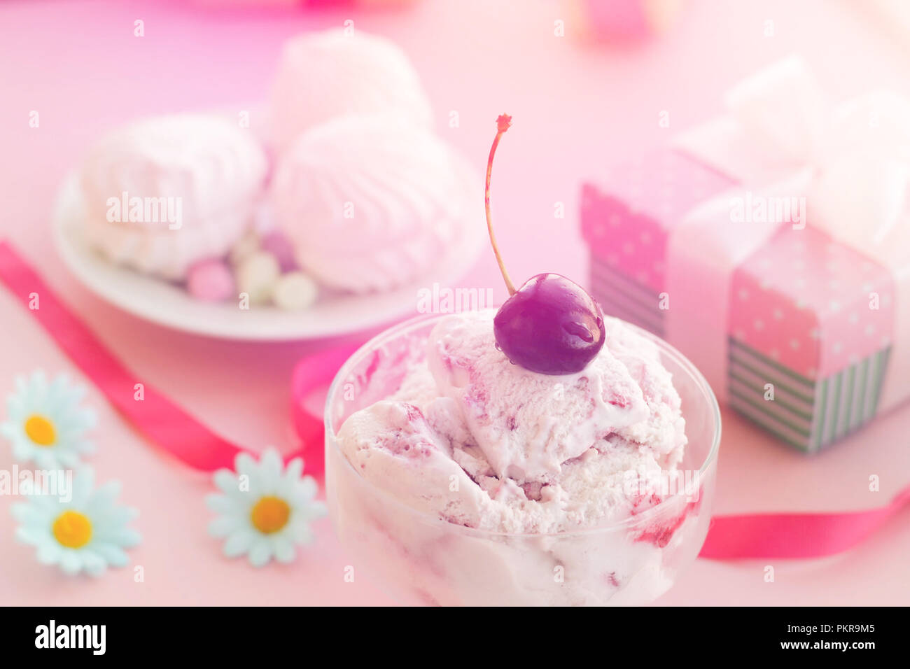 Eis in einer Schale, die neben der Marshmallows, Blumen, rosa Süßigkeiten. Stockfoto