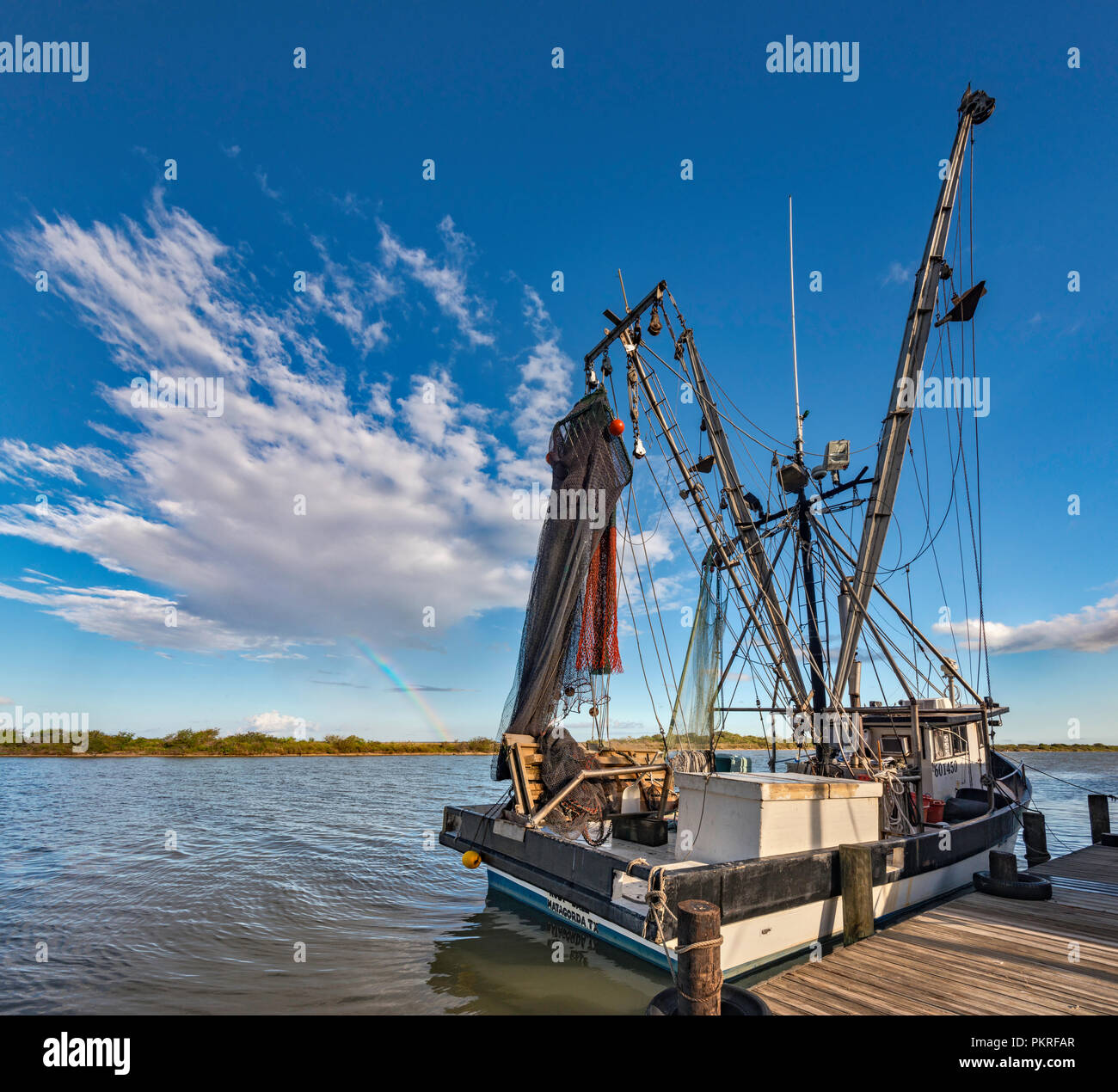 Krabbenkutter am Pier an den Colorado River in der Nähe seiner Mündung in den Golf von Mexiko, Regenbogen in der Entfernung, in der Nähe der Matagorda, Texas, USA Stockfoto