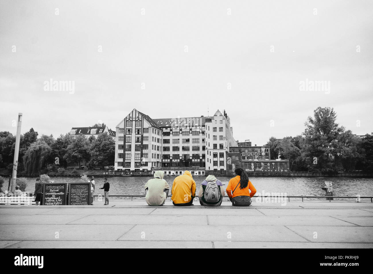 Eine Gruppe junger Leute sitzen auf die Schritte, die in der Nähe der Berlin Fluss Stockfoto