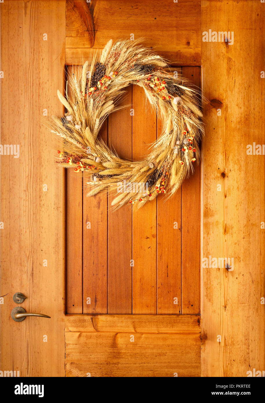 Haus Home Front Tür Herbst Herbst Thanksgiving Dekorationen Landhausstil rustikal Kranz aus natürlichen botanischen Materialien auf Holz Hintergrund Stockfoto