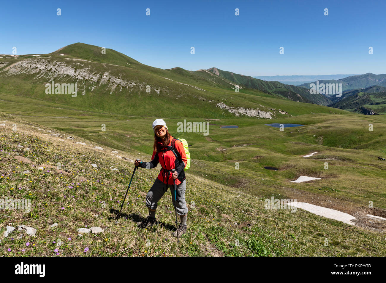 Trekker mit Gebirgsseen und Weide im Hintergrund, Keskenkyia Loop trek, Jyrgalan, Kirgisistan Stockfoto