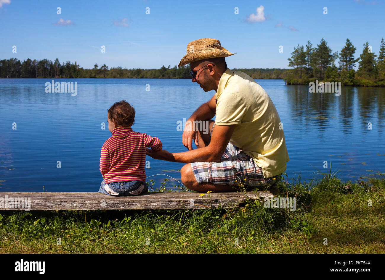 Redhead Kleinkind bei einem Spaziergang an einem See mit Vater - Vaterschaft Konzept Stockfoto
