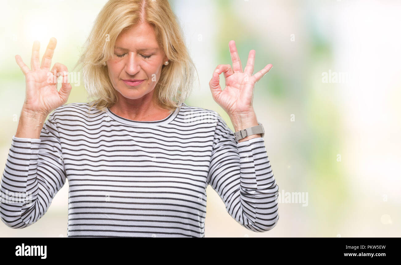 Blonde Frau mittleren Alters über isolierte Hintergrund entspannen und Lächeln mit den Augen dabei geschlossen Meditation Geste mit den Fingern. Yoga Konzept. Stockfoto