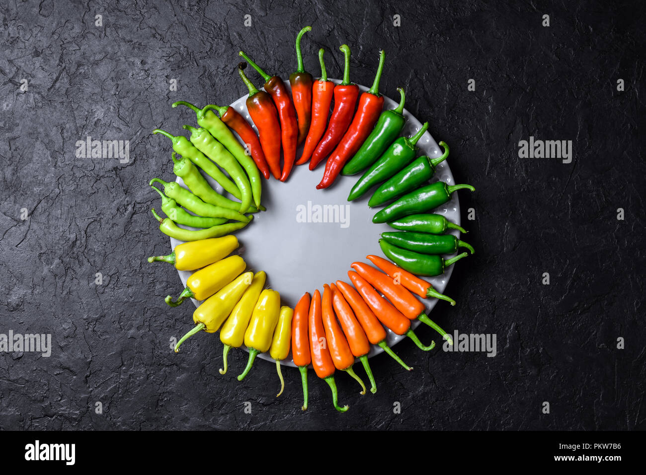 Verschiedene Farben Peperoni in hölzerne Platte Stockfoto