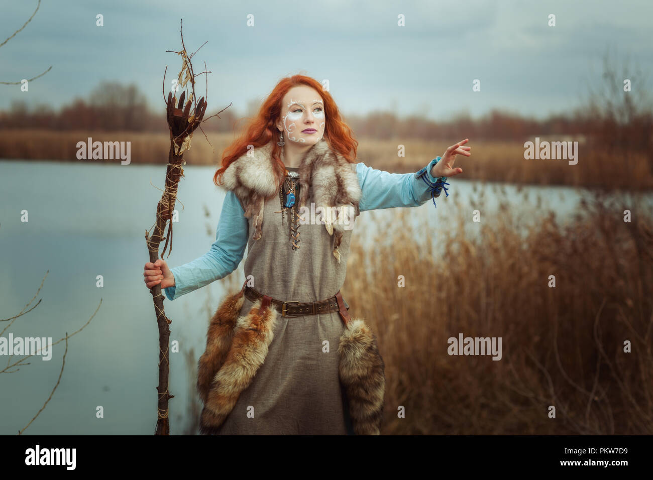 Heidnische Frau ist ein Schamane mit einem Stab in den Händen. Stockfoto