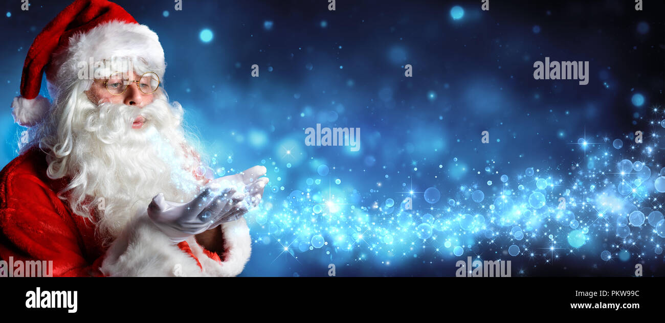 Santa Claus Blasen Magic Christmas Stars in schneereichen Nacht Stockfoto