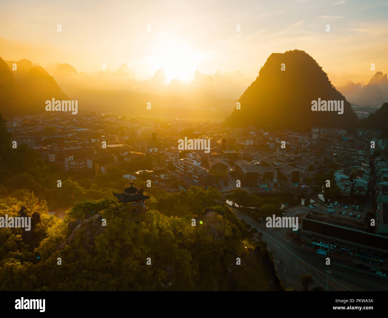 Luftbild von einem Sonnenaufgang über den Bergen und der Stadt von Guangxi China Stockfoto