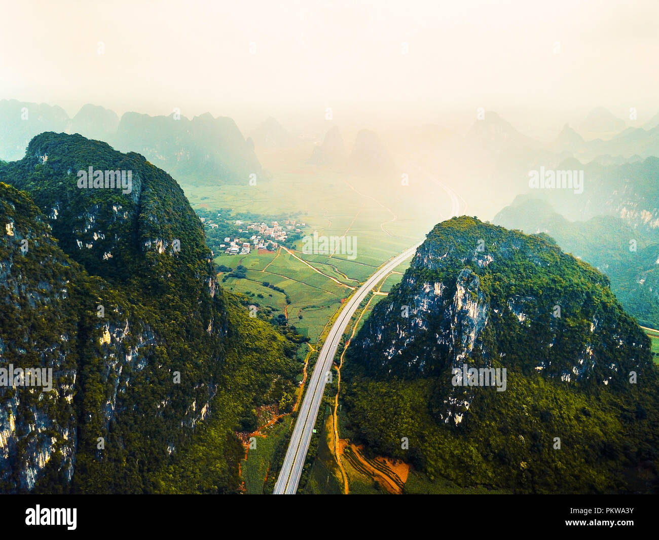 Luftbild der Karstgebirge und Highway in China an einem nebligen Tag Stockfoto