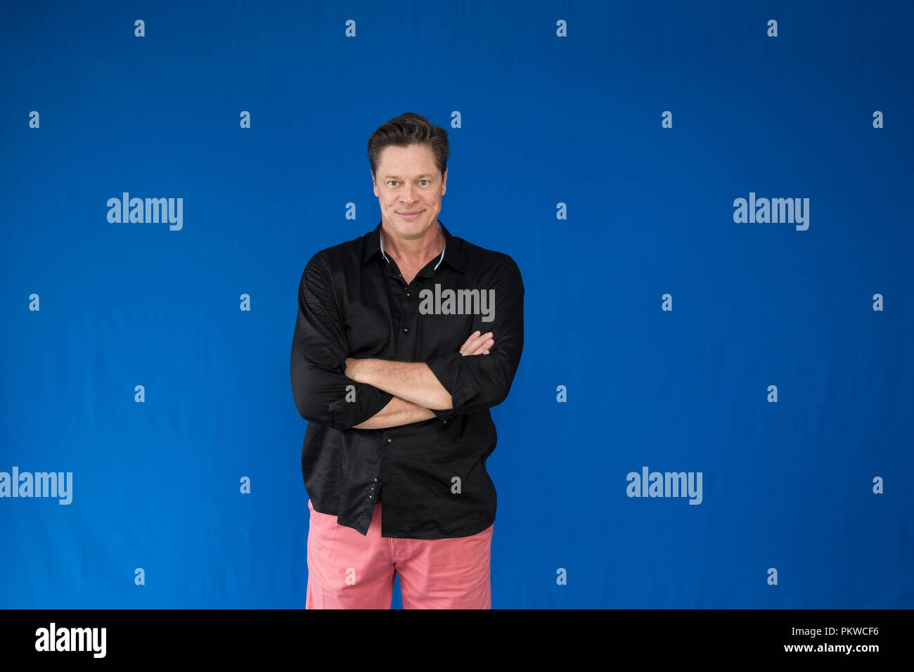 Schöner Mann mit verschränkten Armen. Stockfoto