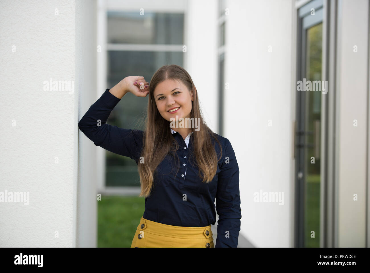 Young Business Frau steht außerhalb der Gebäude, lächeln Stockfoto