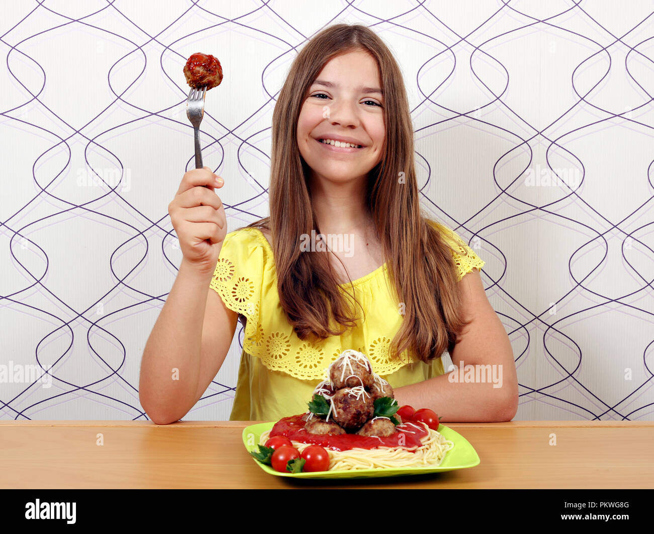 Schöne glückliche Mädchen mit Frikadellen und Spaghetti zum Mittagessen Stockfoto
