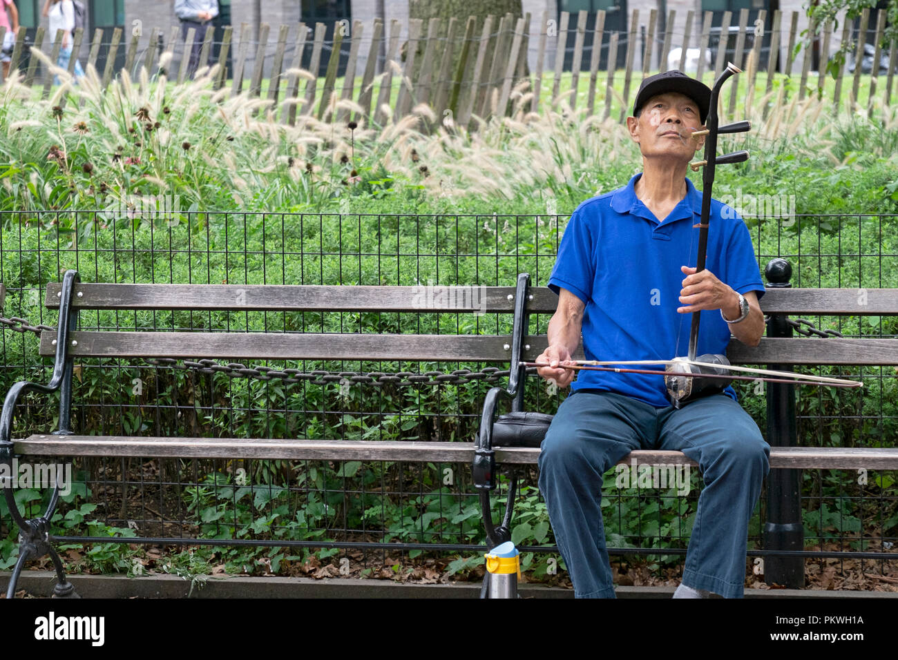 Eine ältere die chinesisch-amerikanische spielt die ehru auf einer Bank in Washington Square Park in Manhattan, New York City. Stockfoto