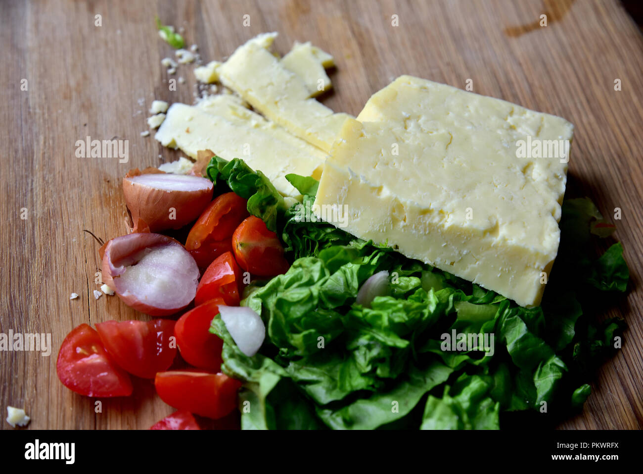 Home food Vorbereitung. Hausgemachtes Rindfleisch Burger, Pommes und Salat zubereitet in einer eigenen Küche. Bild zeigt Salat, Salat, Käse, Tomaten und Pommes Frites. Stockfoto