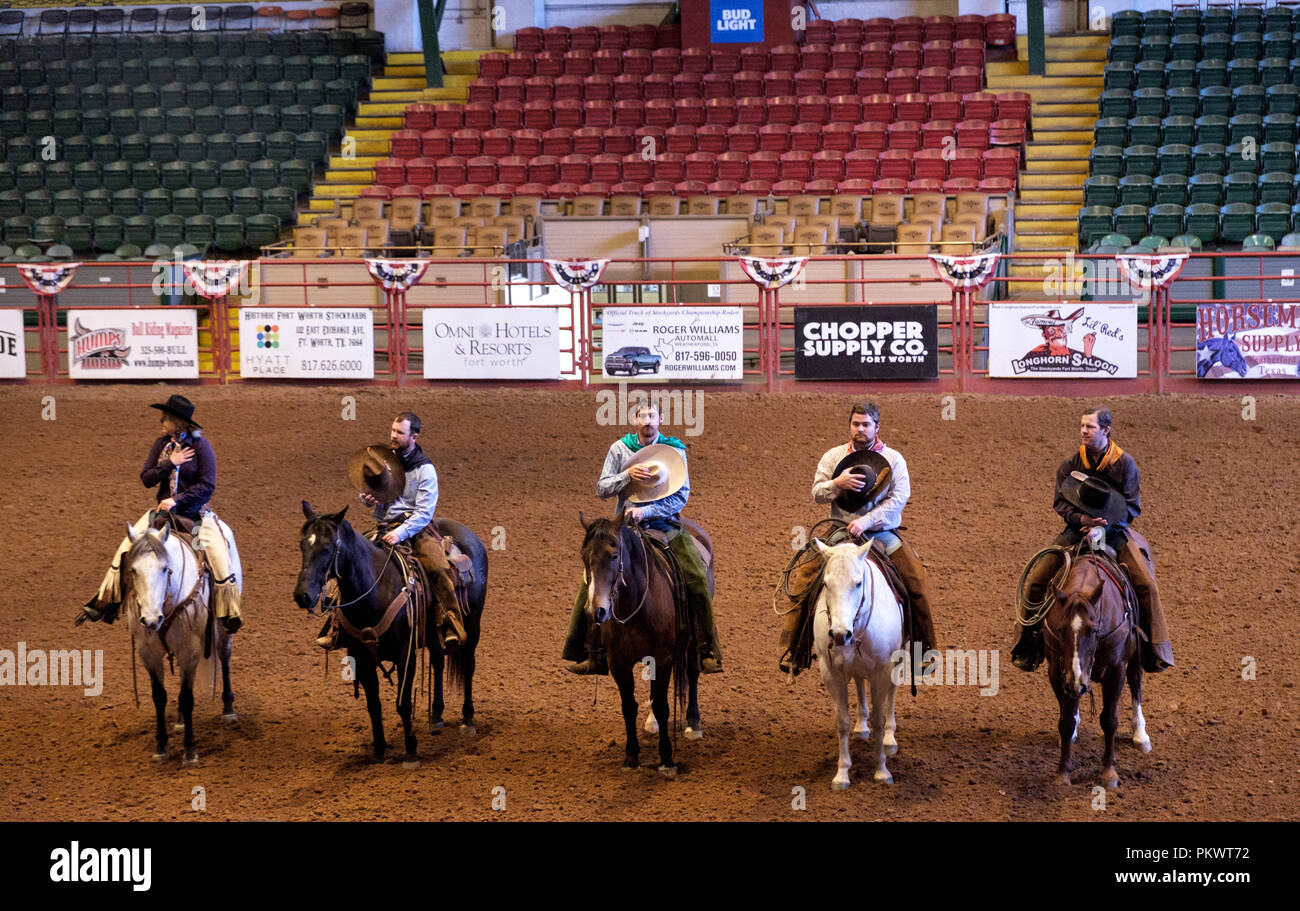 Staycation. Cowboys auf Pferden legen Hüte in die Herzen und lauschen der amerikanischen Nationalhymne bei der Wild West Rodeo Show von Pawnee Bill. Ft. Worth Texas. Stockfoto
