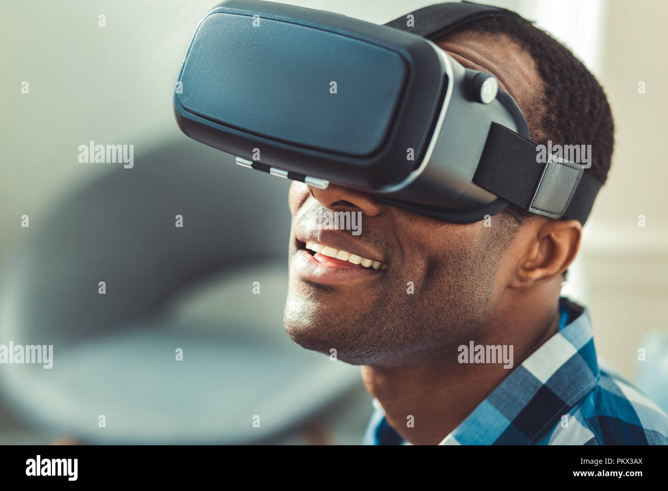 Froh, afro-amerikanische Mann tuning VR-Headset Stockfoto