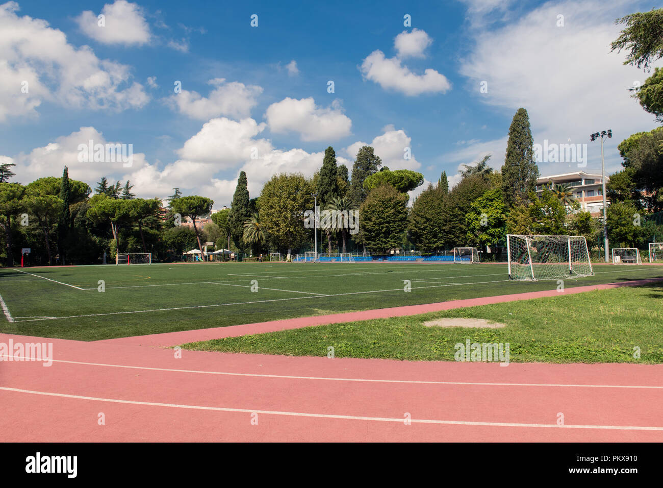 Weite Einstellung auf grünen Fußballfeld im Park mit Leichtathletikbahn und Bäume um, kein Volk Querformat Stockfoto