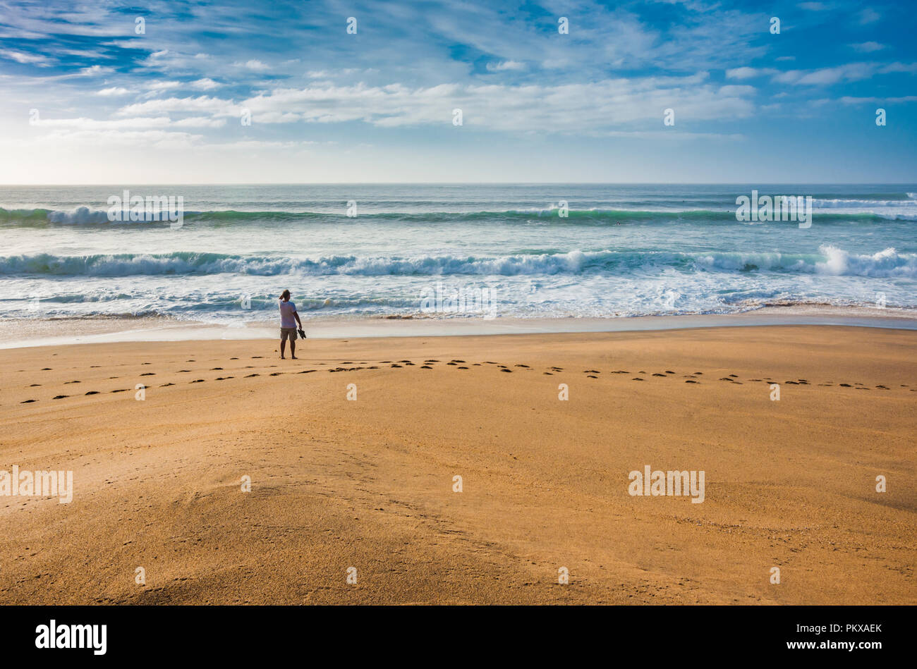 Mann, der am Strand mit Blick auf das Meer Stockfoto
