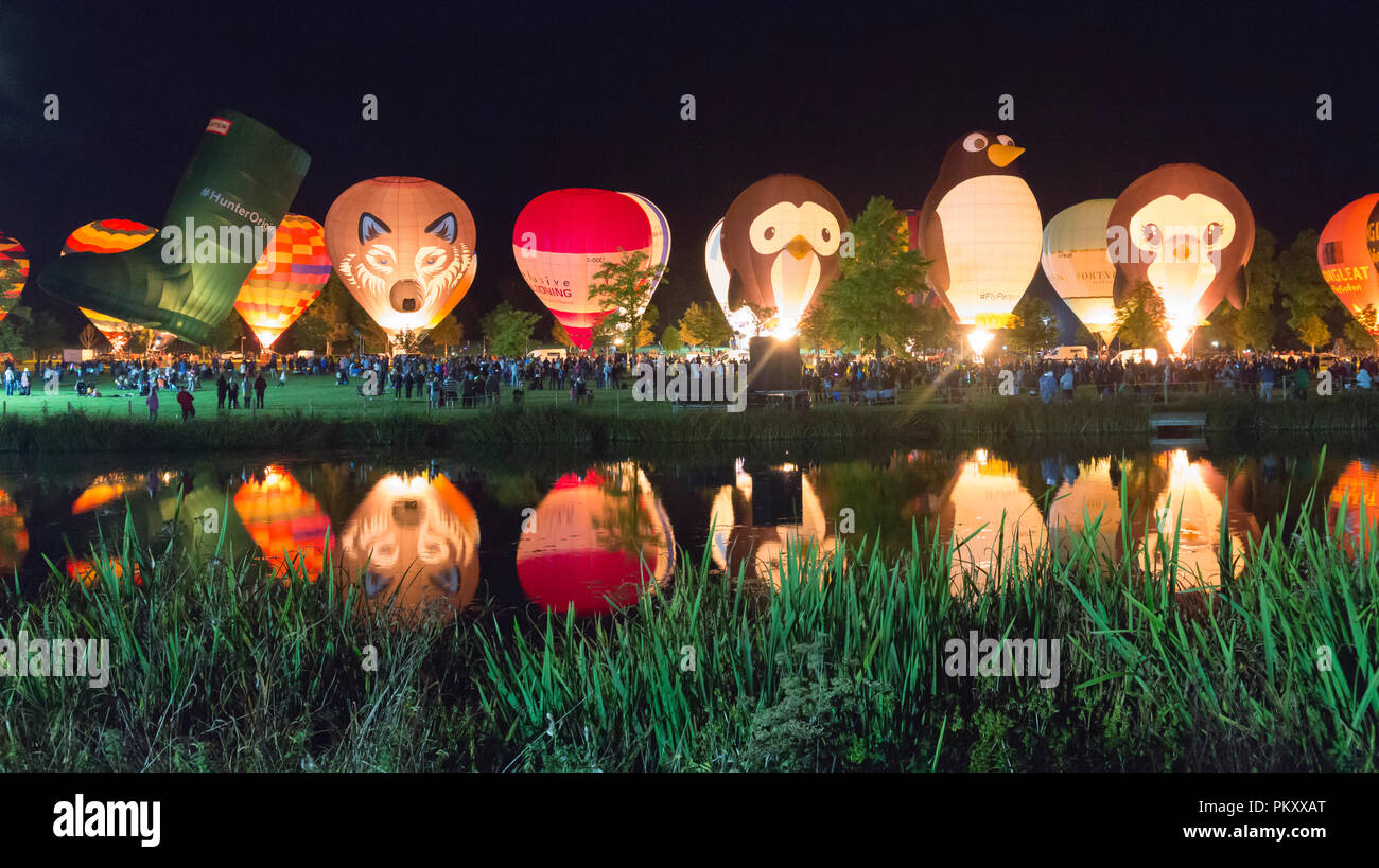 Longleat, Wiltshire, UK. 15 Sep, 2018. Nach einem erfolgreichen Tag fliegen mit dem schönen Wetter, tausende Leute zu sehen, die Heißluftballons in den nächtlichen Himmel der Himmel Longleat Safari Nacht Glühen beleuchtet. Der Ballon Festival ist das Größte in Großbritannien. Reihe von Heißluftballons, die im Dunkeln leuchten von Musik begleitet, und im Wasser des Sees spiegelt. Credit: Carolyn Jenkins/Alamy leben Nachrichten Stockfoto