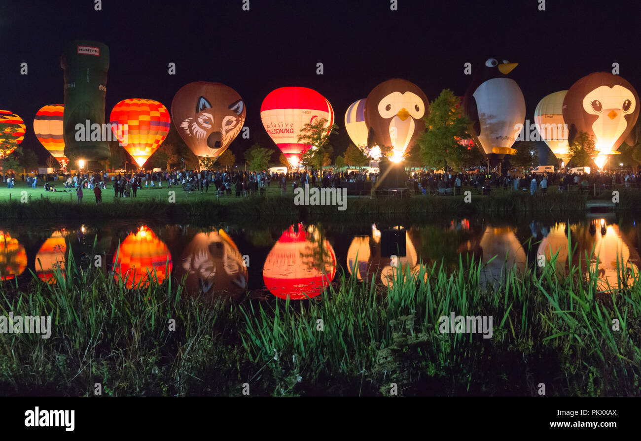 Longleat, Wiltshire, UK. 15 Sep, 2018. Nach einem erfolgreichen Tag fliegen mit dem schönen Wetter, tausende Leute zu sehen, die Heißluftballons in den nächtlichen Himmel der Himmel Longleat Safari Nacht Glühen beleuchtet. Der Ballon Festival ist das Größte in Großbritannien. Reihe von Heißluftballons, die im Dunkeln leuchten von Musik begleitet, und im Wasser des Sees spiegelt. Credit: Carolyn Jenkins/Alamy leben Nachrichten Stockfoto