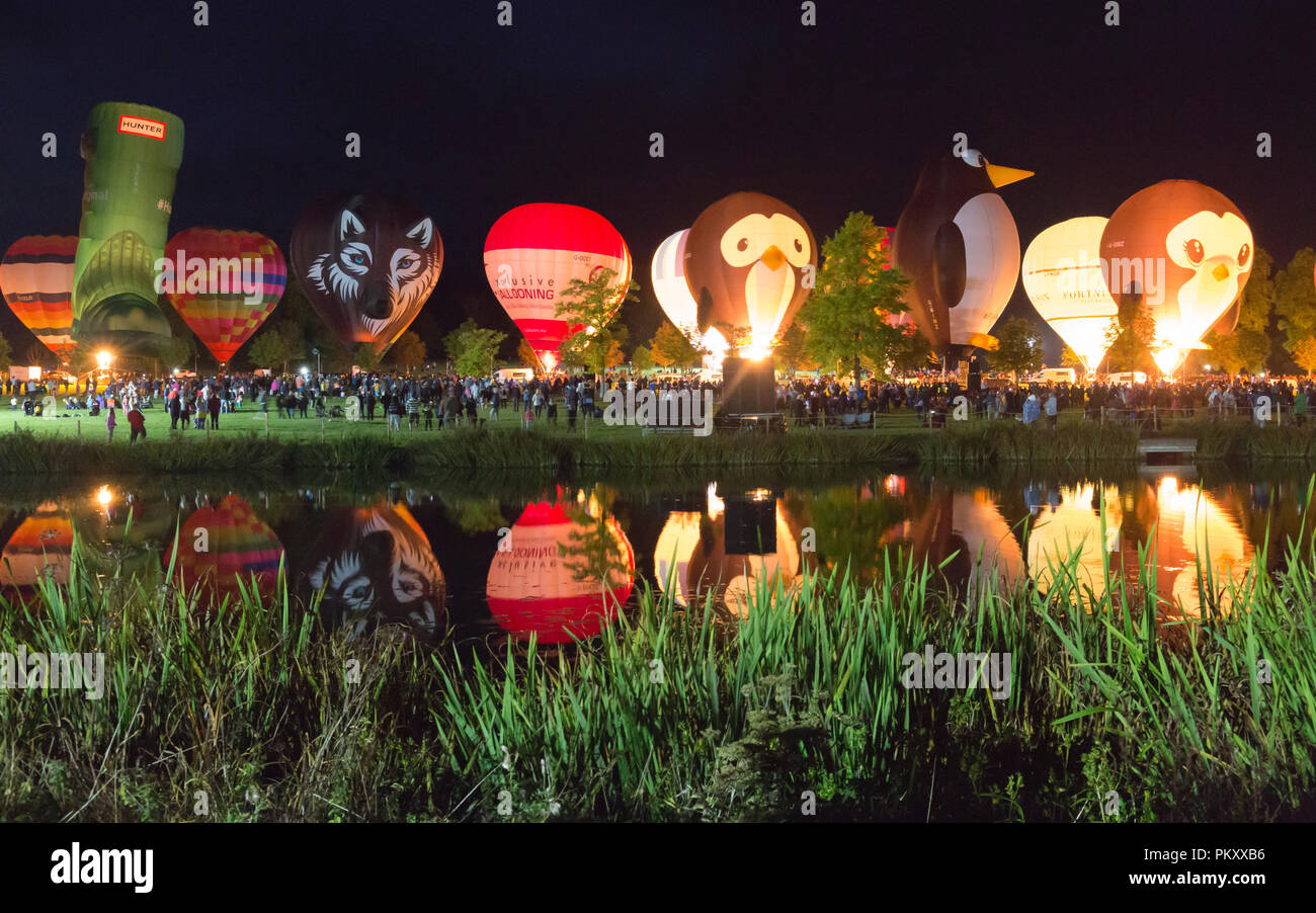 Longleat, Wiltshire, UK. 15 Sep, 2018. Nach einem erfolgreichen Tag fliegen mit dem schönen Wetter, tausende Leute zu sehen, die Heißluftballons in den nächtlichen Himmel der Himmel Longleat Safari Nacht Glühen beleuchtet. Der Ballon Festival ist das Größte in Großbritannien. Reihe von Heißluftballons, die im Dunkeln leuchten von Musik begleitet, und im Wasser des Sees spiegelt. Credit: Carolyn Jenkins/Alamy leben Nachrichten Stockfoto