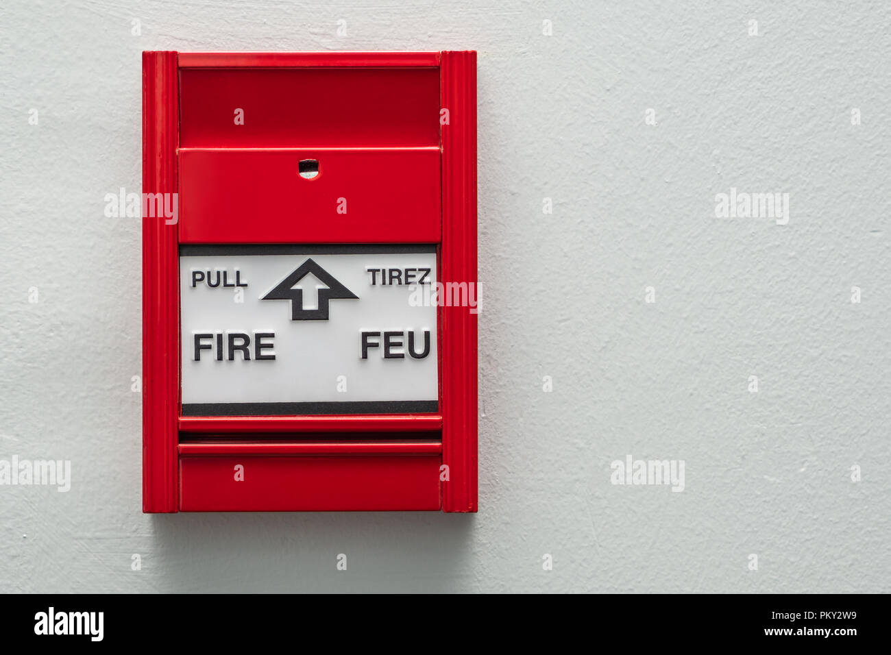 Feueralarm Pull Station auf einer neutralen farbigen Wand montiert. Stockfoto
