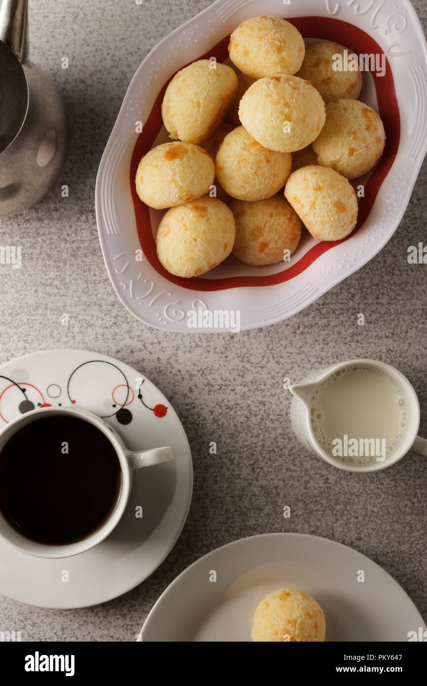 Blick von oben auf einen einfachen brasilianischen Frühstück, mit Kaffee, Milch und Käse Brot (auch bekannt als Pao De Queijo). Stockfoto