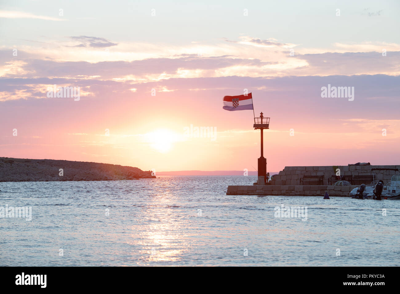 Kroatische Flagge im Wind bei Sonnenuntergang fliegen im Hafen Stockfoto