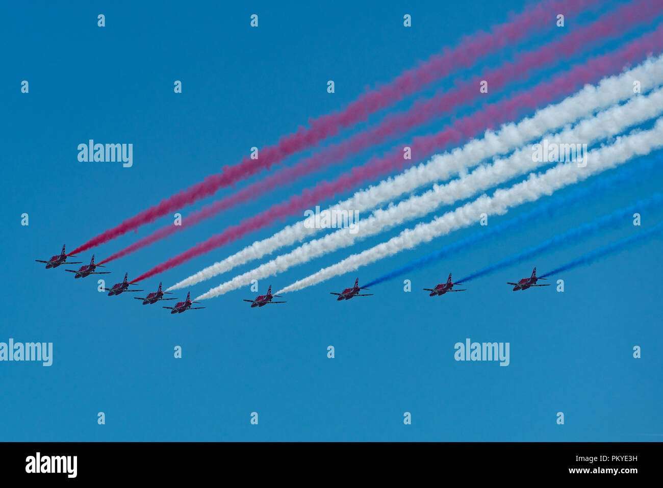 Die roten Pfeile tun ein Flypast in grossen neun Bildung trailing patriotischen Rauch auf Streitkräfte Tag in Llandudno Stockfoto
