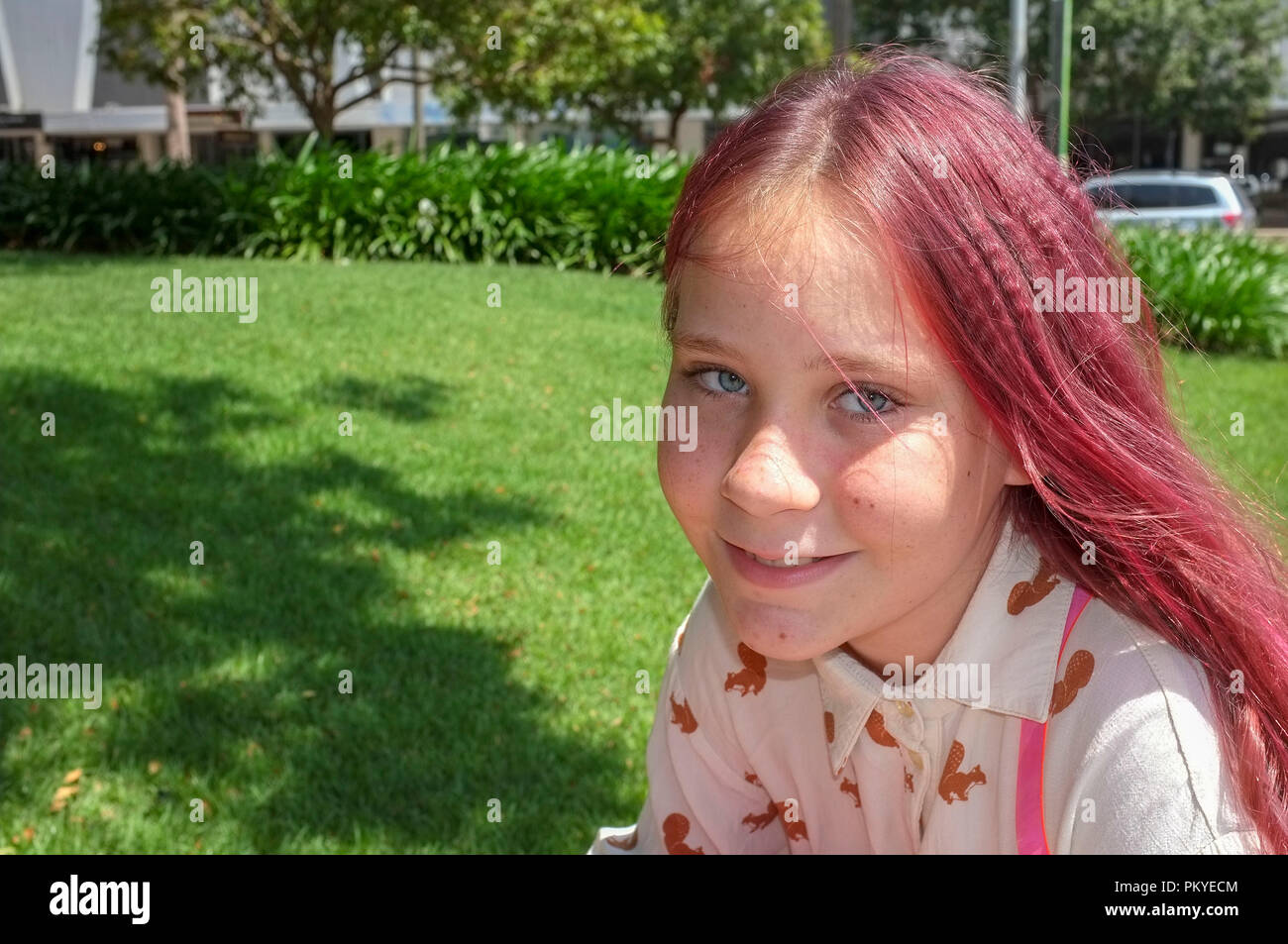 Junge Mädchen mit rosa und gekräuselten Haar in die Kamera. Stockfoto