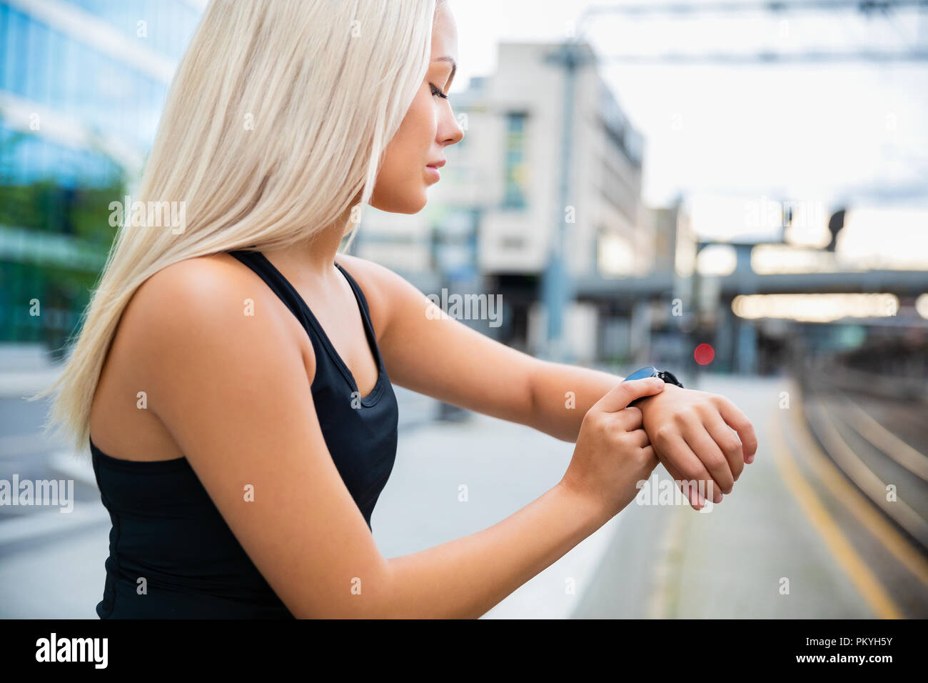 Fit weibliche Begleitung ihre Leistung auf Smartwatch nach Workou Stockfoto