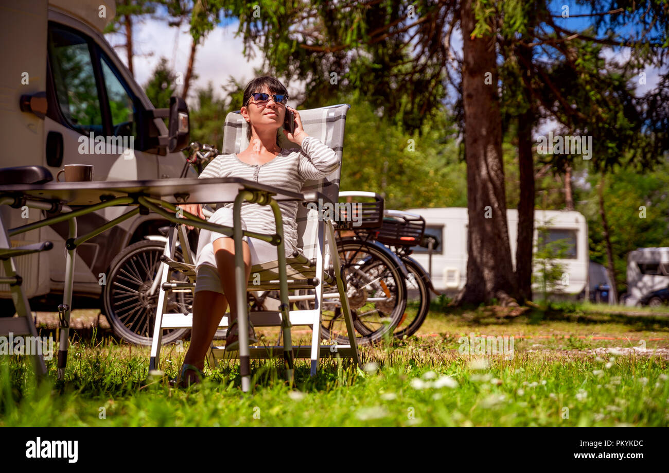 Frau sprechen über Smart Phone im Freien in einem Campingplatz für Urlauber. Caravan Auto Urlaub. Familie Urlaub Reisen, Urlaub im Reisemobil RV. Con Stockfoto