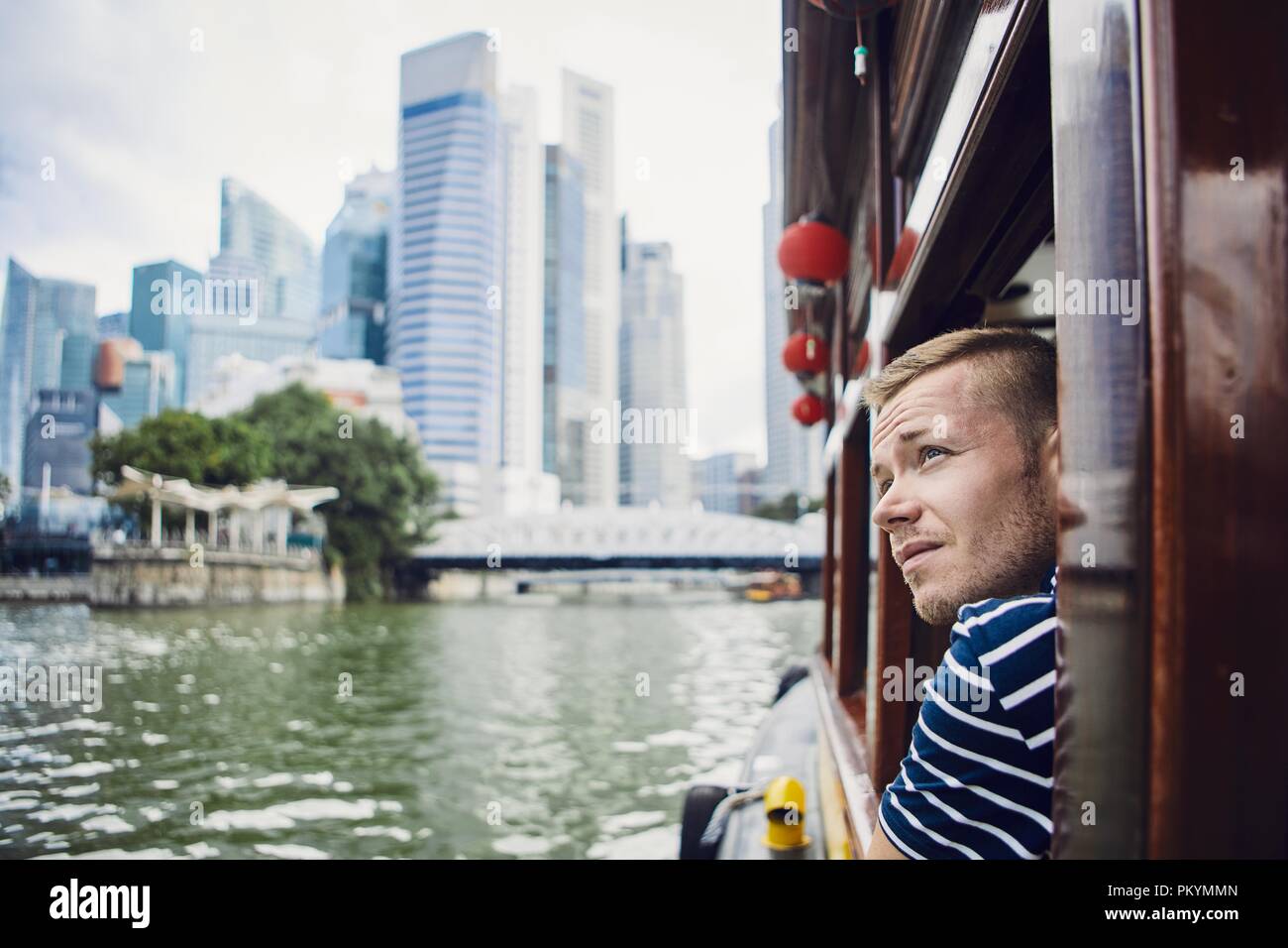 Junger Mann erkunden Stadt und in River Boat in Singapur. Stockfoto