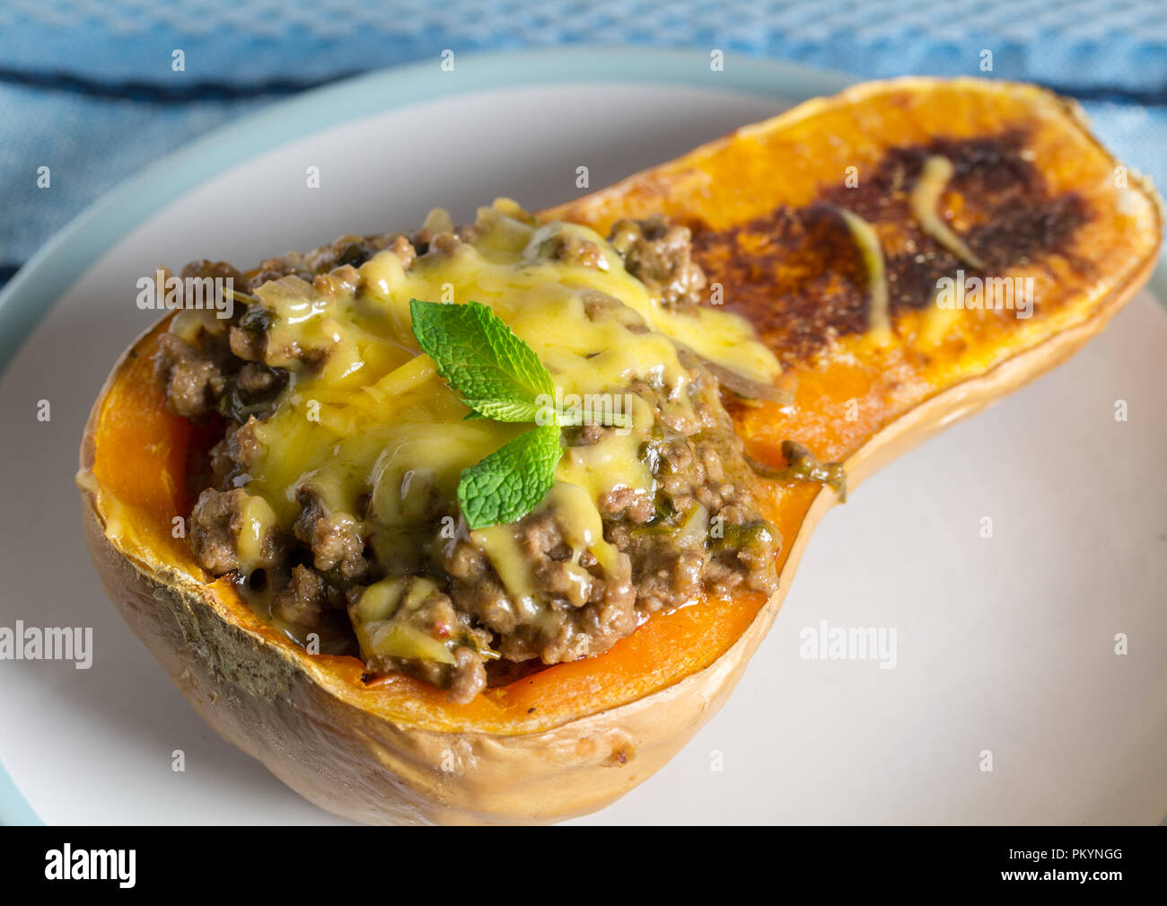 Gebackener butternut gefüllt mit Linsen, Fleisch und Gemüse mit geschmolzenem Käse oben Mince Stockfoto