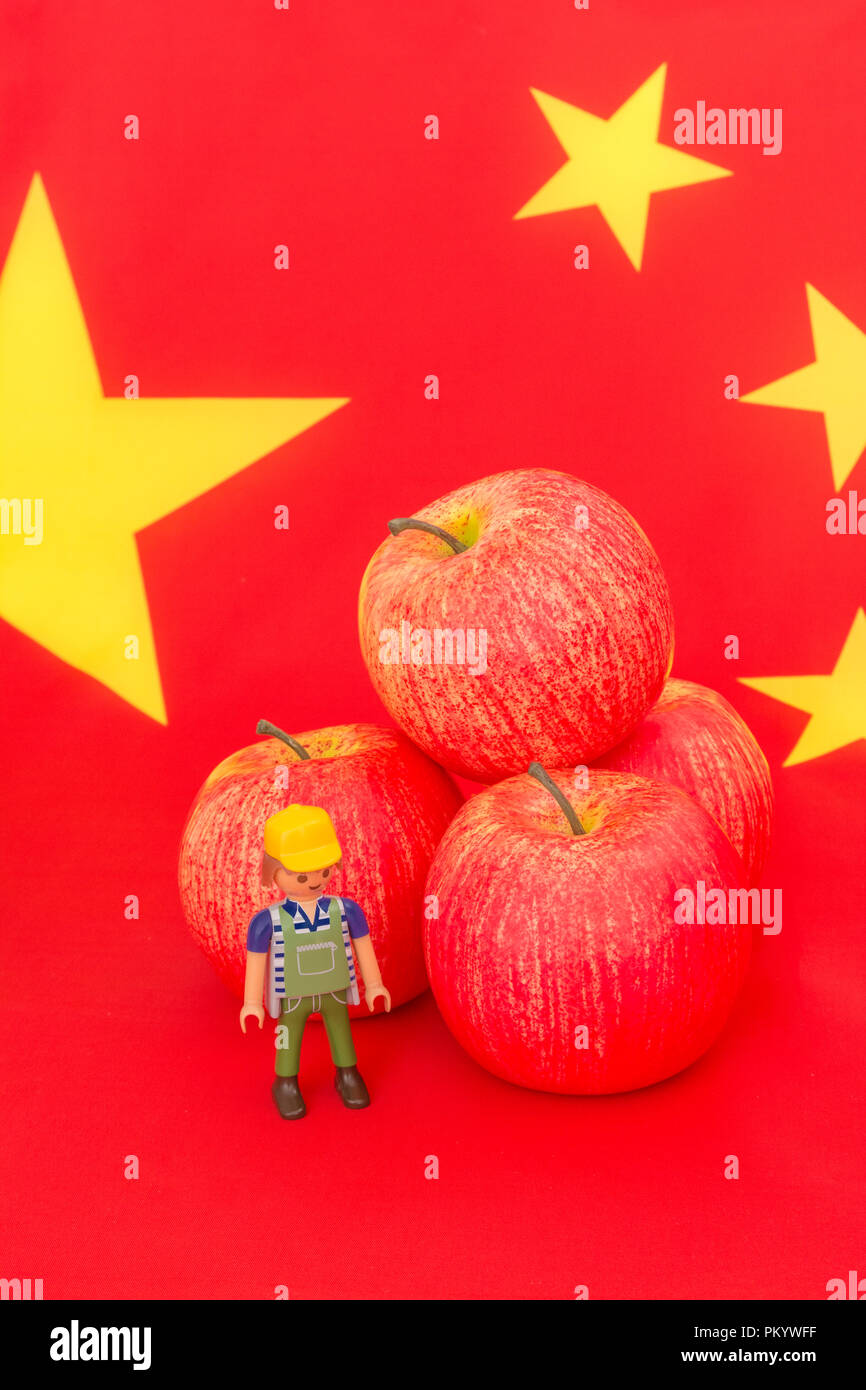 Uns red apple Ausfuhren mit Chinesischen Flagge und kleines Spielzeug Landwirt - Metapher US Apple Industrie, chinesischen Handel Zölle auf Importe aus den USA Äpfel. Stockfoto