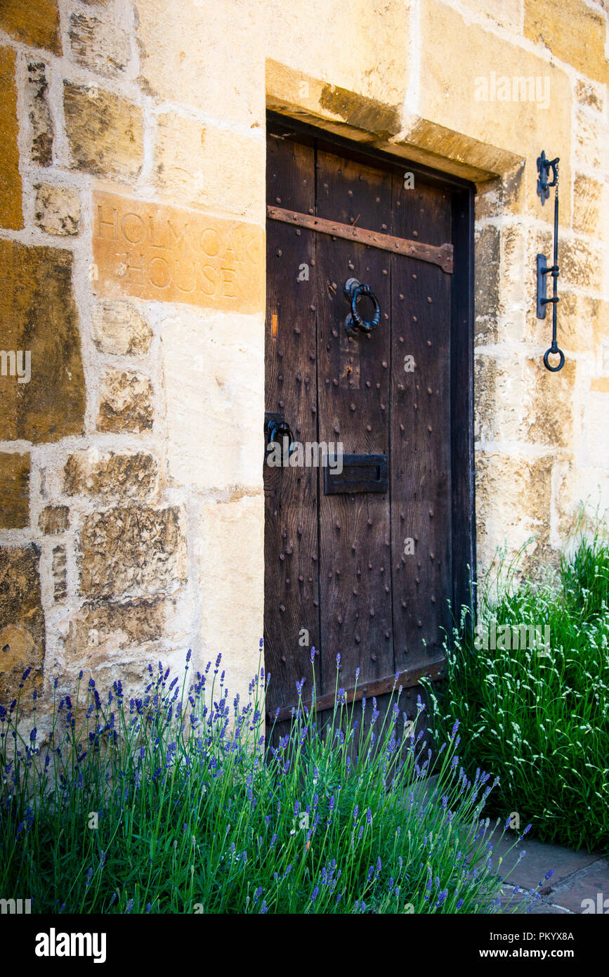 Mittelalterliche Eingangstür am Broadway in honigfarbenem Stein im Cotswolds District von England. Stockfoto