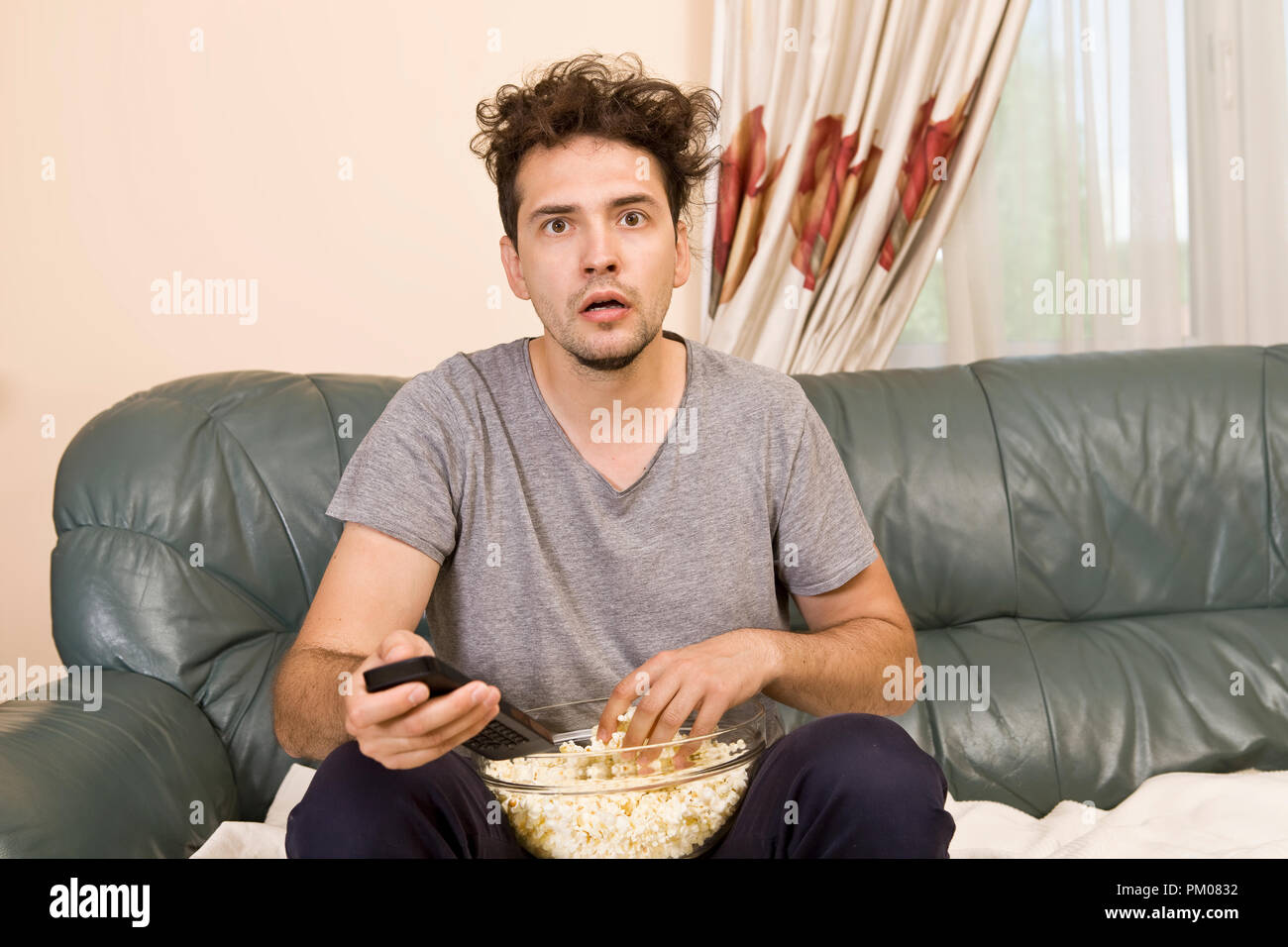 Mann mit Bier und Popcorn Fernsehen zu Hause Stockfoto