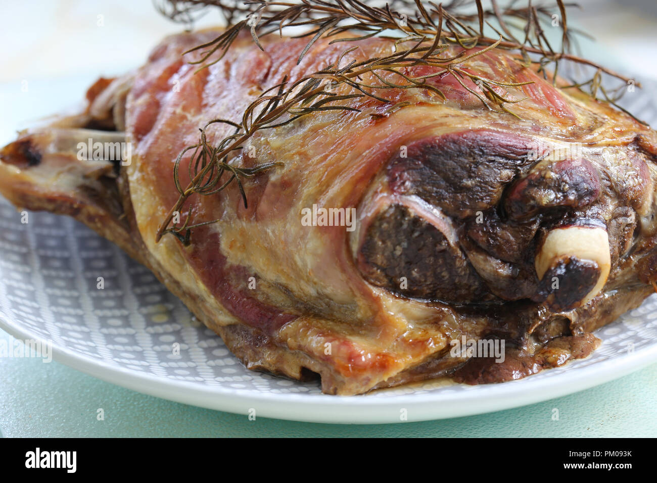 Frisch zubereiteten Lammbraten Schulter auf einem Teller mit einem Rosmarin Kraut garnieren Stockfoto