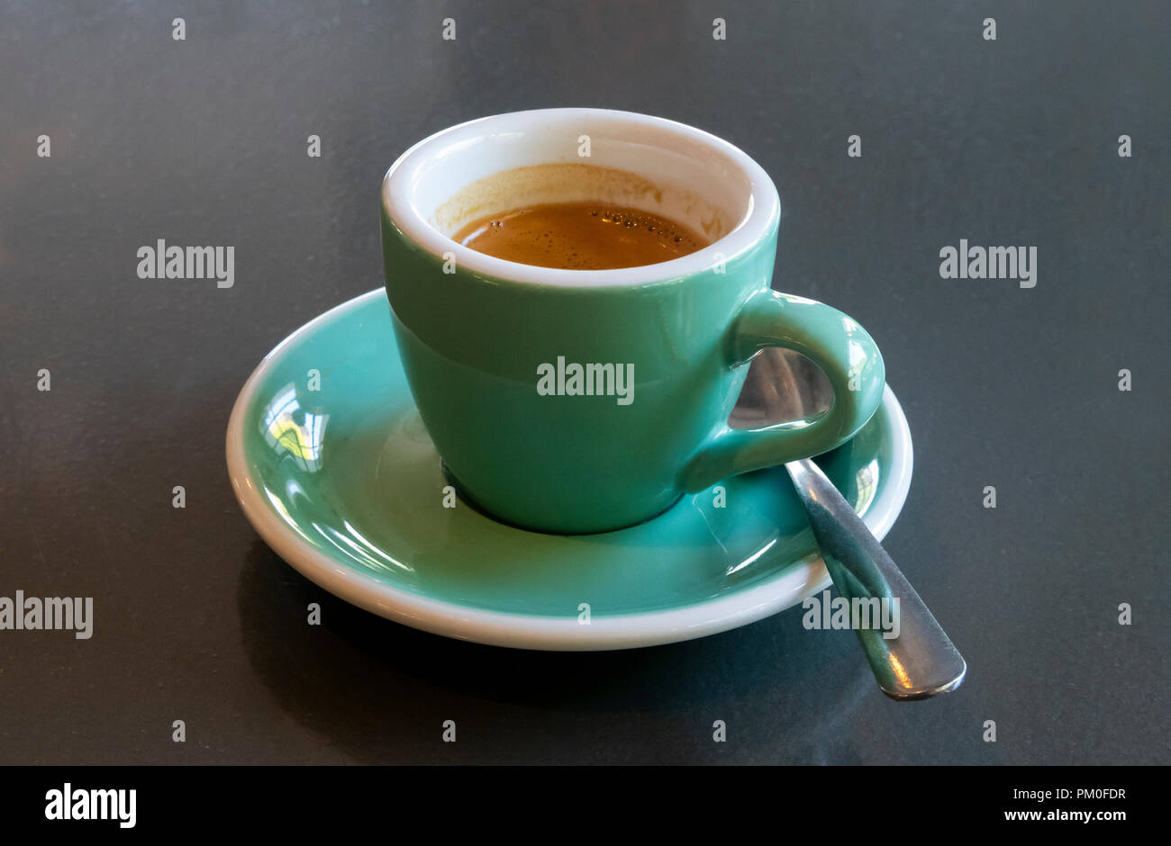 Espresso in einem kleinen grünen Tasse und Untertasse Stockfoto