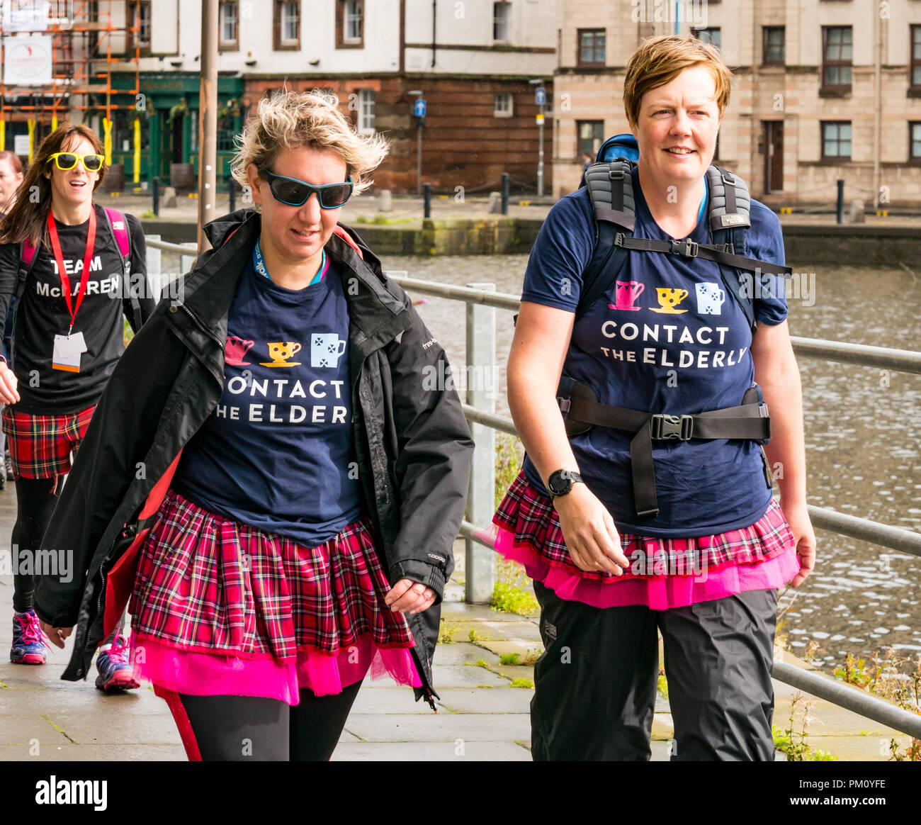 Leith, Edinburgh, Schottland, Großbritannien, 16. September 2018. Edinburgh Kilt Walk, gesponsert von der Royal Bank of Scotland, findet heute statt. Wanderer sammeln Mittel für eine Wohltätigkeitsorganisation ihrer Wahl. Die Kilt Walker erreichen die Küste in Leith bei etwa Meile 14. Frauen in kostümierten Kilts laufen am Flussufer entlang und sammeln Geld für wohltätige Zwecke Stockfoto