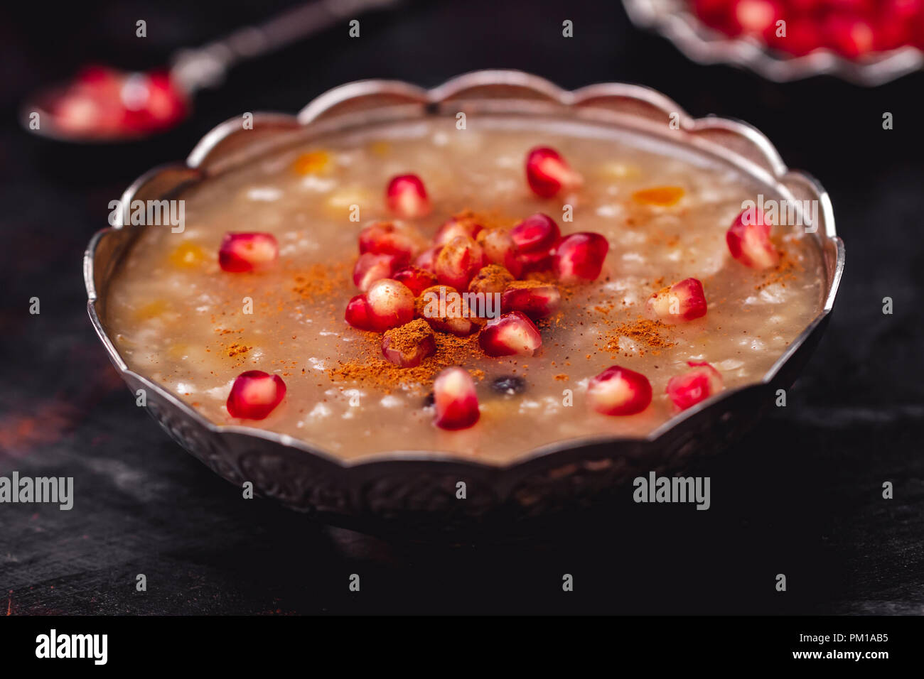 Türkisches dessert Ashura mit Granatapfel, Noahs Pudding, in Metall Schüssel serviert. Stockfoto
