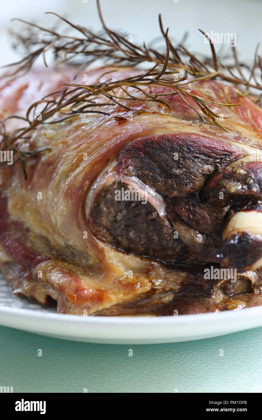 Frisch zubereiteten Lammbraten Schulter auf einem Teller mit einem Rosmarin Kraut garnieren Stockfoto