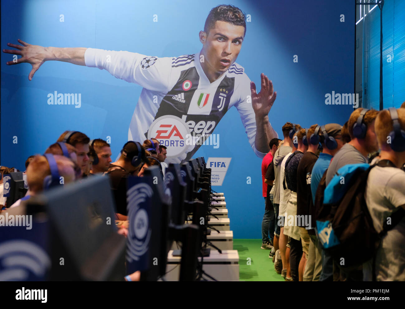 Kšlnmesse, Köln Messe Deutschland, 24.8.2018, Gamer spielen das neue FIFA 19 Fußball video Spiel vor einem übergroßen Bild von Christiano Ronaldo im Trikot von Juventus Turin bei der weltweit größten Computer- und Videospiele messe Gamescom Stockfoto