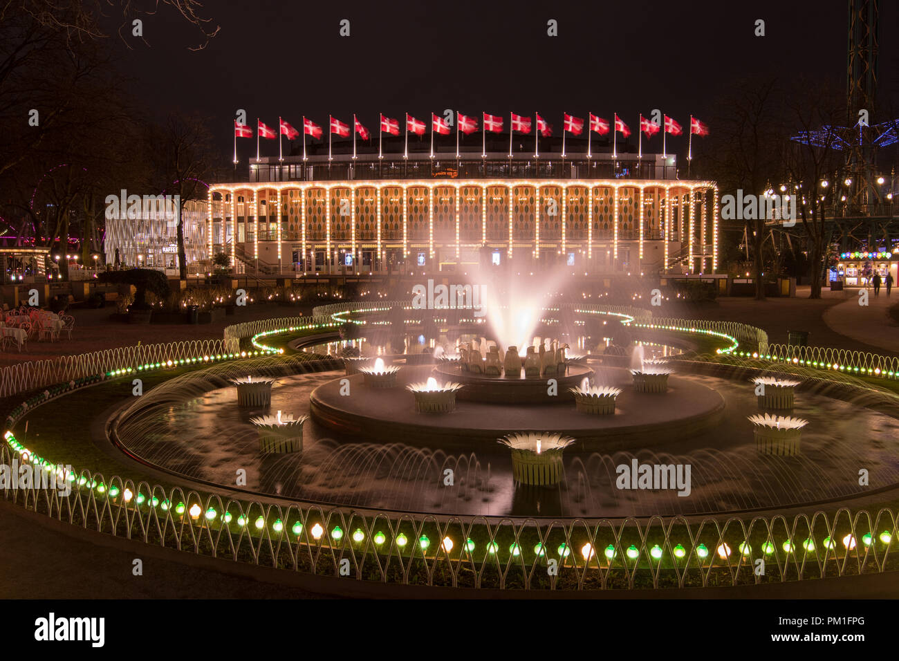 Kopenhagen, Dänemark, 31. MÄRZ 2018: Der Tivoli Concert Hall ist nachts beleuchtet, geschmückt mit 19 Dänische Flaggen, wie der Brunnen in der fo-Betrieb Stockfoto